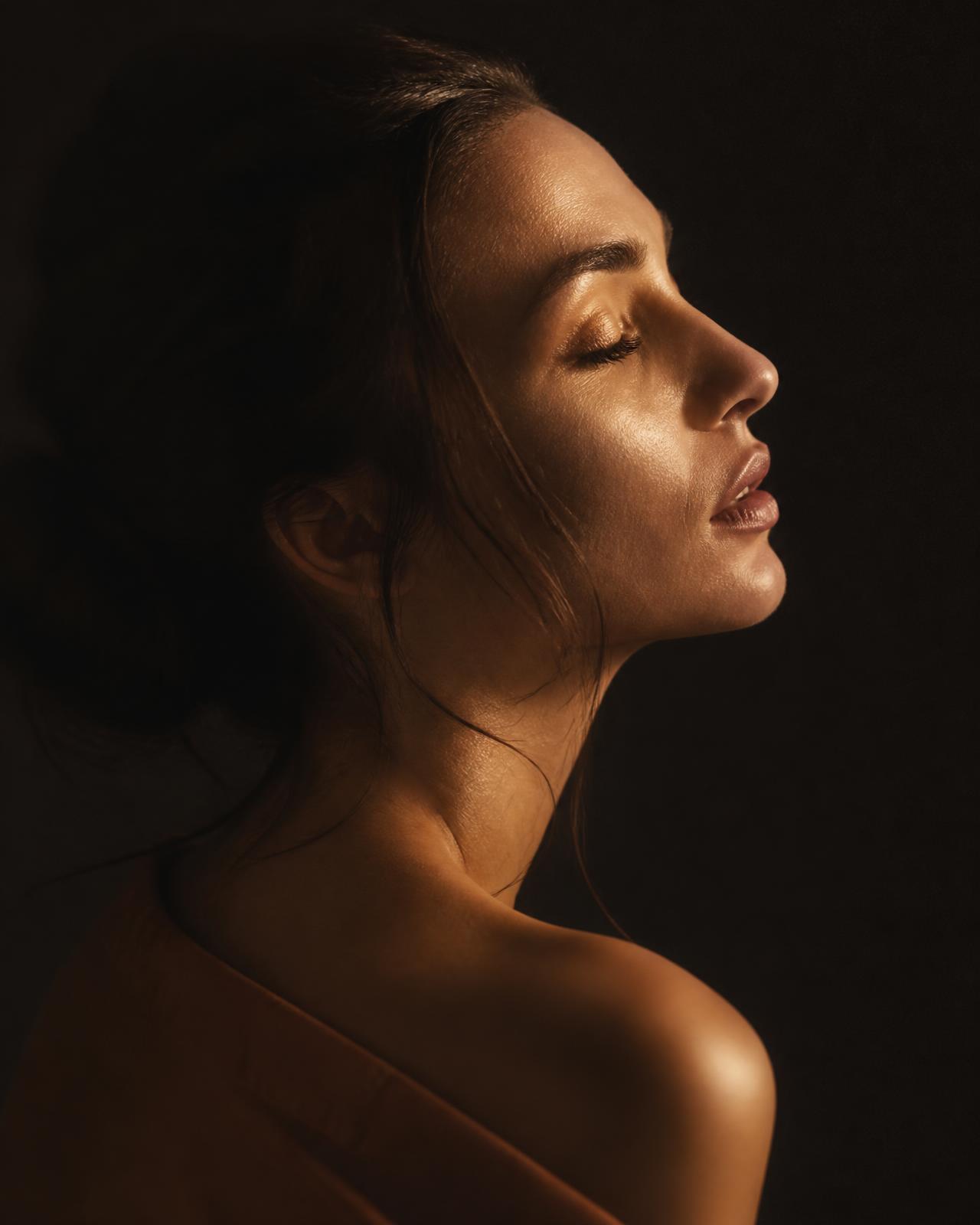 Mulher em silêncio, iluminada por uma luz dourada suave
